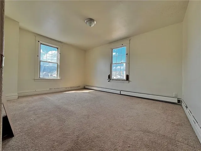 an empty room with windows and mirror