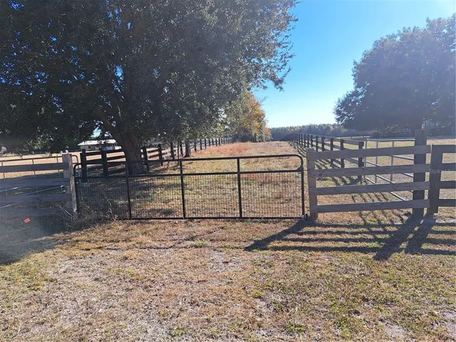 a view of a yard with wooden fence