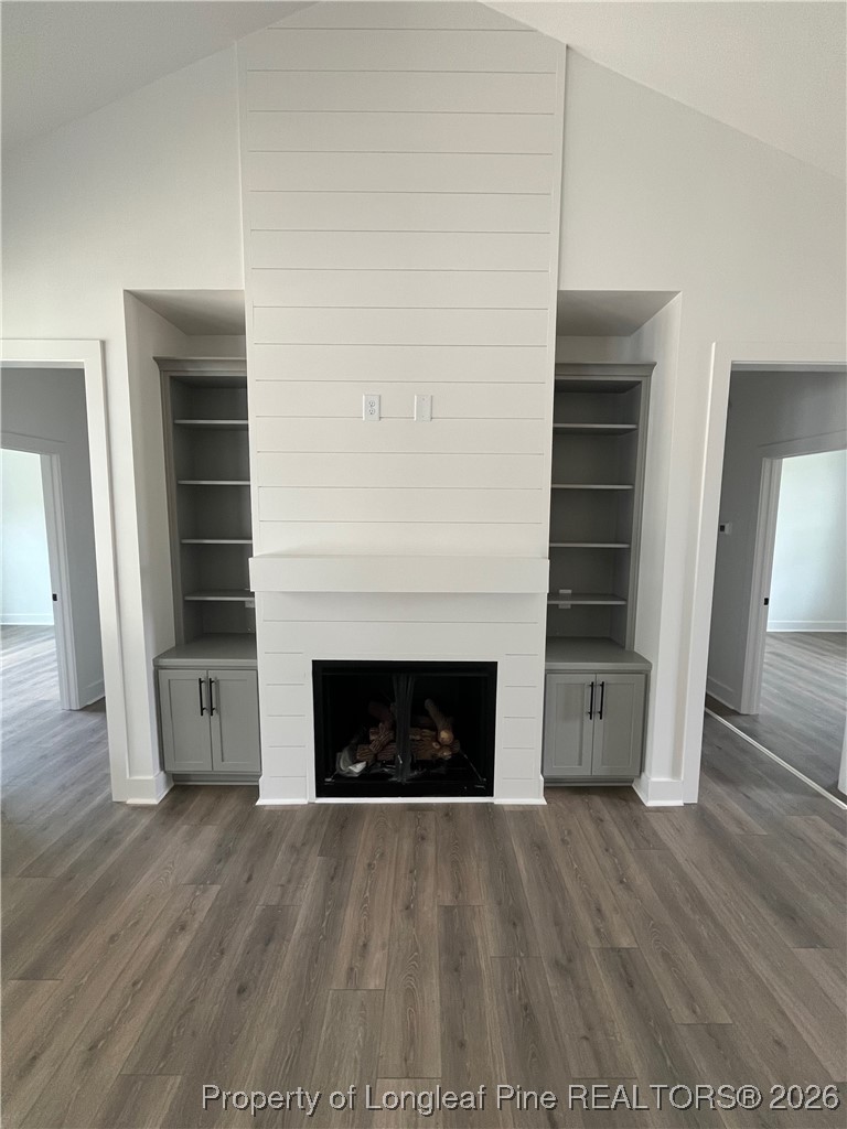 115 Keyser Street Aberdeen, NC 28315 - Photo 2 of 17 an empty room with wooden floor fireplace and windows