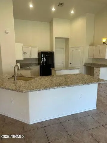 a kitchen with granite countertop a sink and white cabinets