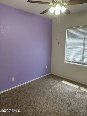 a view of an empty room with a chandelier fan