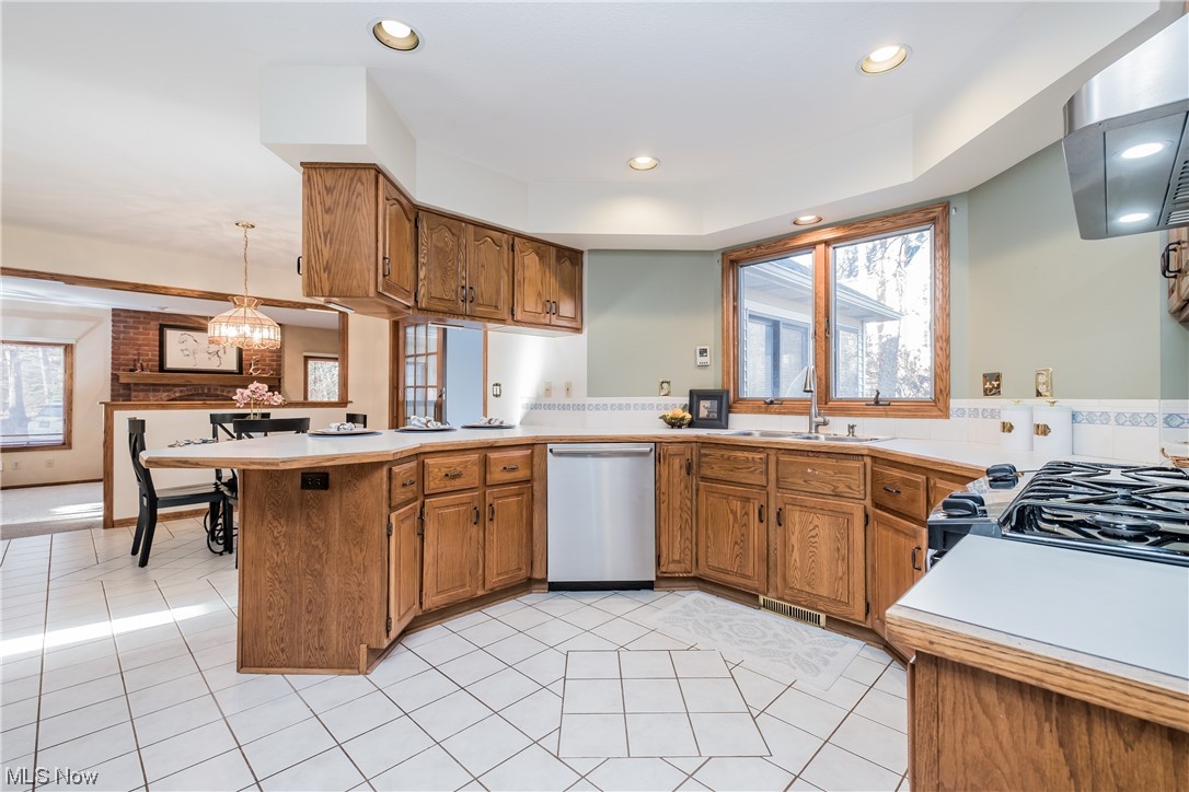 6216 Rockside Circle Northwest Canton, OH 44718 - Photo 11 of 33 Kitchen with light tile floors, sink, stainless steel dishwasher, and eat in bar