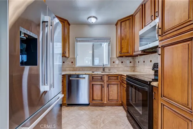 a kitchen with stainless steel appliances granite countertop a refrigerator and a stove