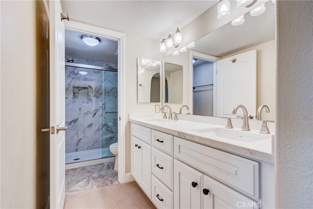 34004 Selva Road, Unit 384 Dana Point, CA 92629 - Photo 16 of 35 a bathroom with a double vanity sink mirror and shower