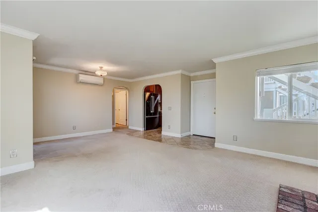a view of an empty room with window and bathroom