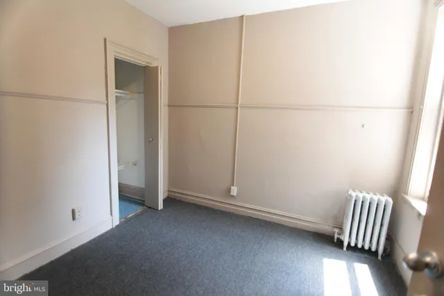 an empty room with wooden floor and glass door
