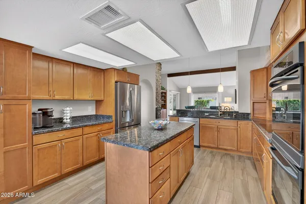 a kitchen with a stove a refrigerator and a dining table with wooden floor