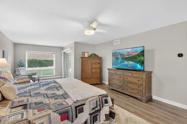 a bedroom with a large bed and a flat tv screen on dresser