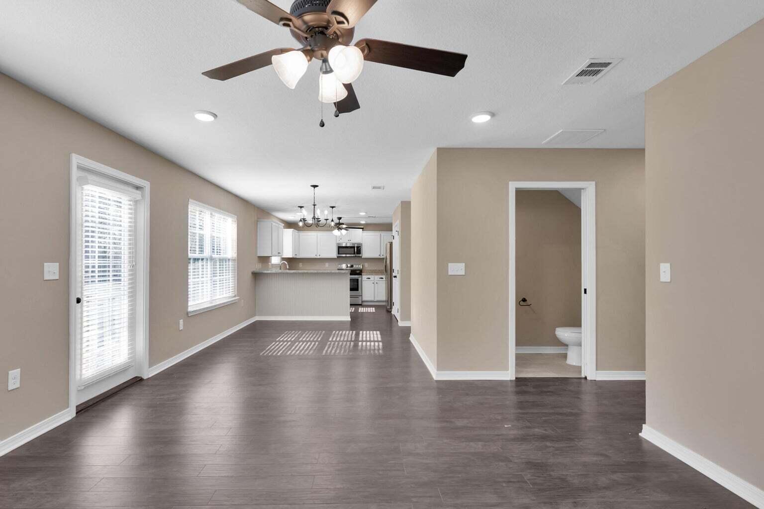 446 Eisenhower Drive Crestview, FL 32539 - Photo 2 of 25 a view of a hallway with wooden floor and a kitchen