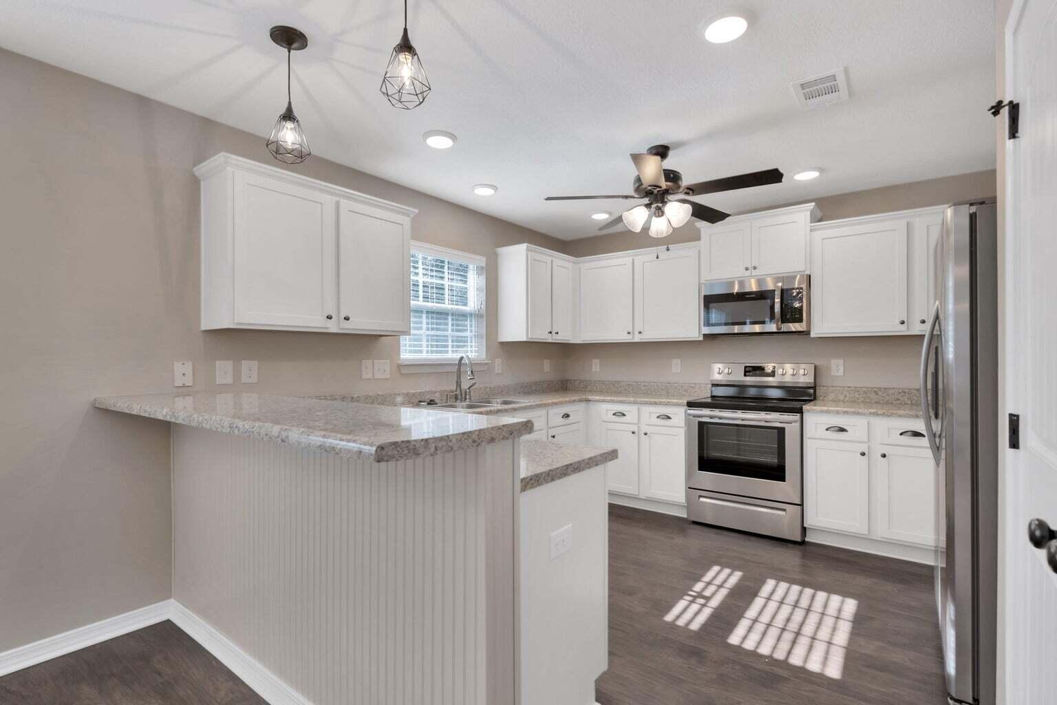 446 Eisenhower Drive Crestview, FL 32539 - Photo 5 of 25 a kitchen with granite countertop a sink stainless steel appliances and cabinets