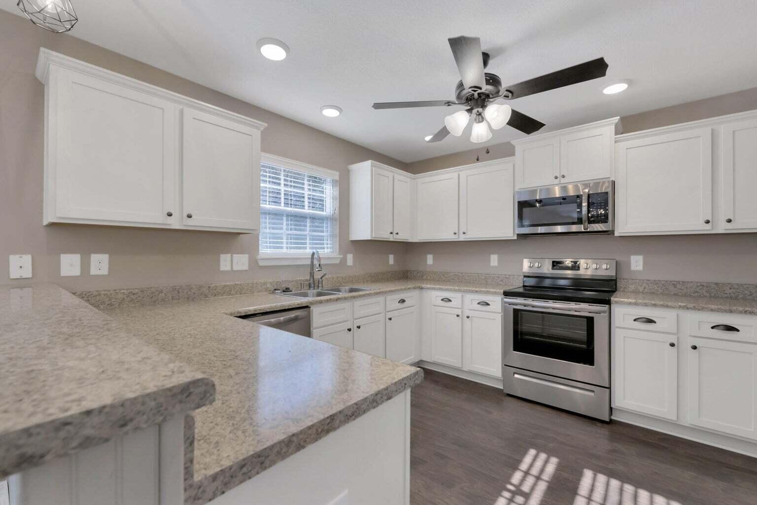 446 Eisenhower Drive Crestview, FL 32539 - Photo 6 of 25 a kitchen with stainless steel appliances granite countertop a sink a stove and a microwave oven