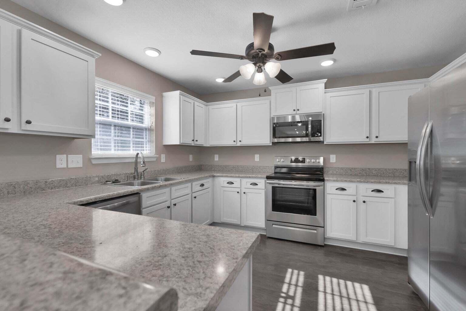 446 Eisenhower Drive Crestview, FL 32539 - Photo 7 of 25 a kitchen with stainless steel appliances granite countertop a stove sink cabinets and window