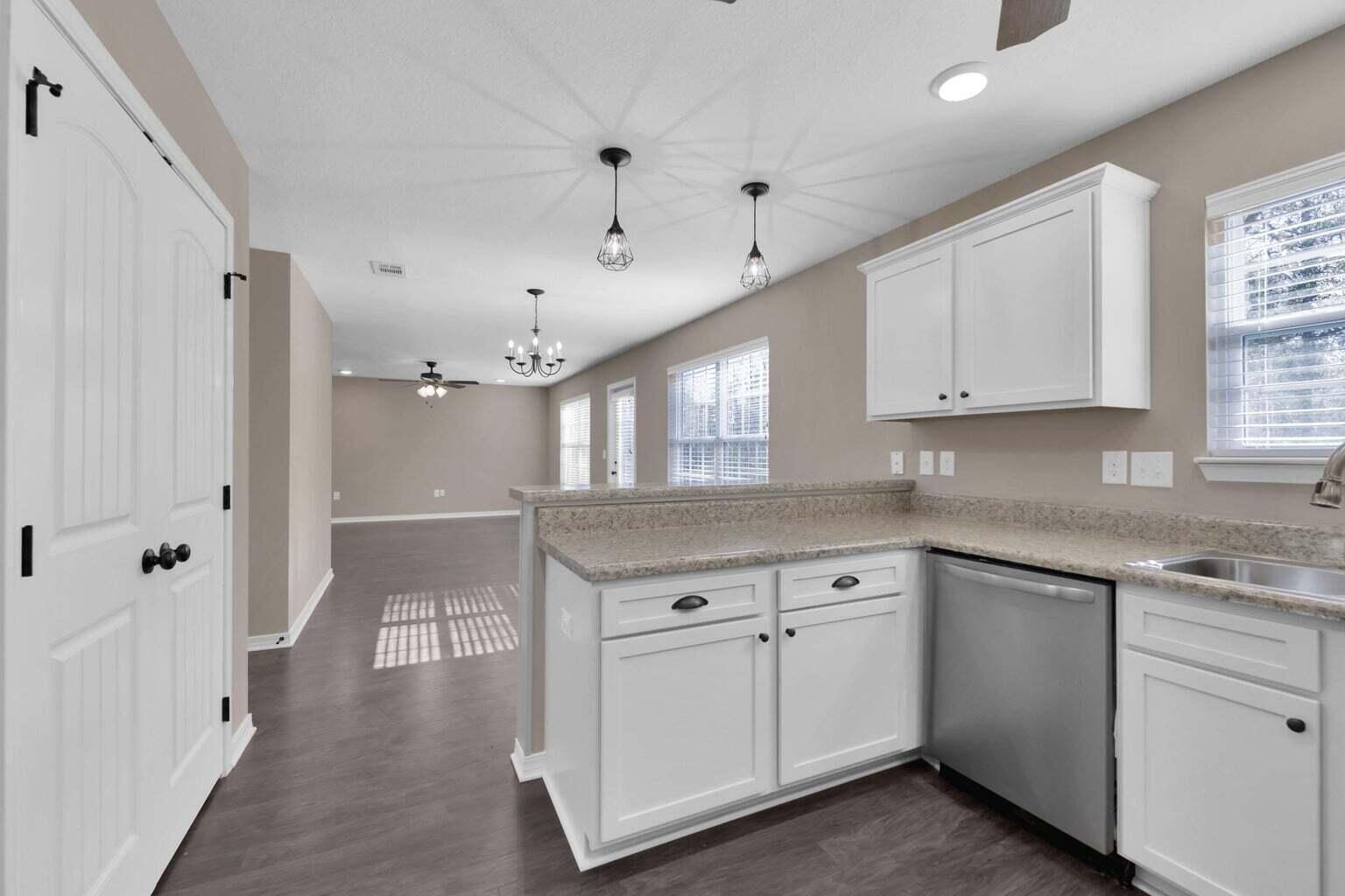 446 Eisenhower Drive Crestview, FL 32539 - Photo 9 of 25 a kitchen with white cabinets and white appliances