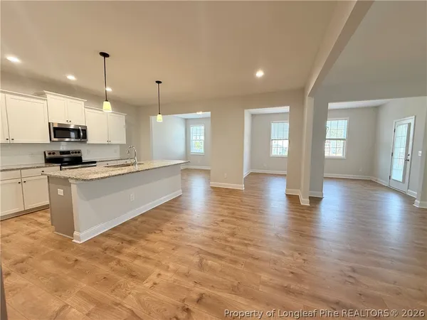 a large kitchen with granite countertop a stove top oven a sink a counter space and cabinets