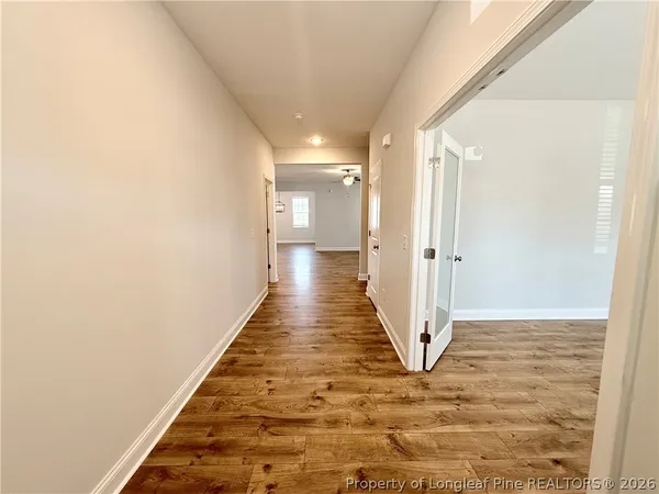 a view of a hallway with wooden floor
