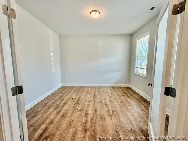 a view of a room with wooden floor and window
