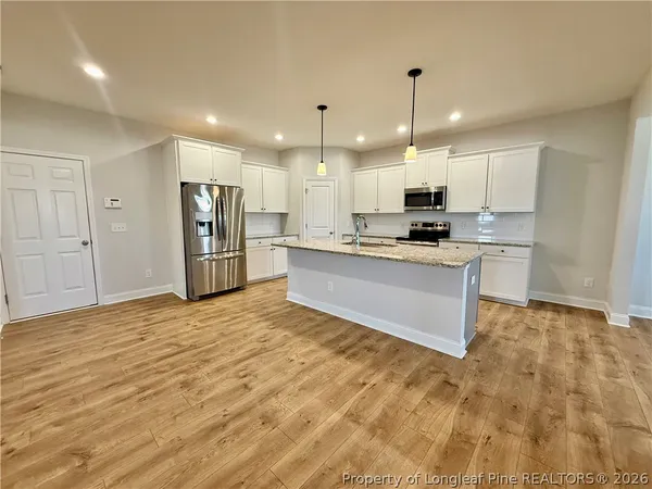 a kitchen with stainless steel appliances granite countertop a refrigerator sink and cabinets