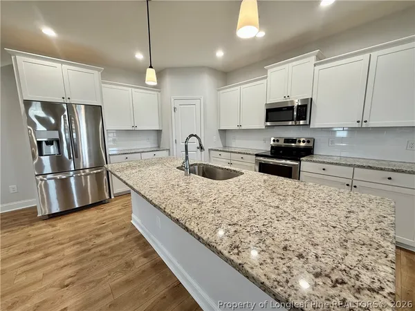 a kitchen with stainless steel appliances granite countertop a sink refrigerator and microwave
