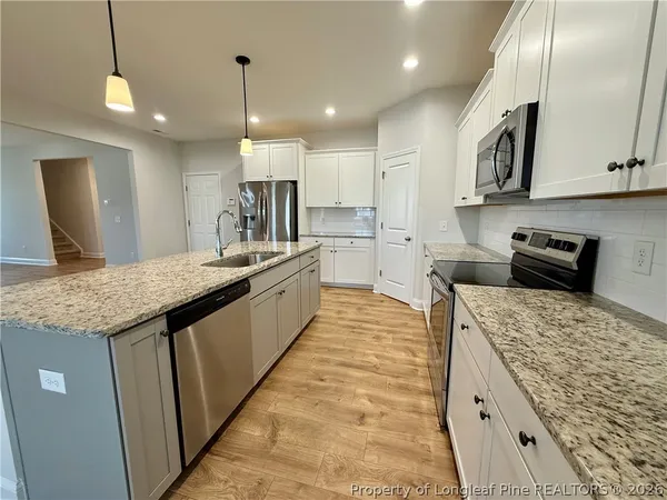 a large kitchen with kitchen island a sink stove and refrigerator