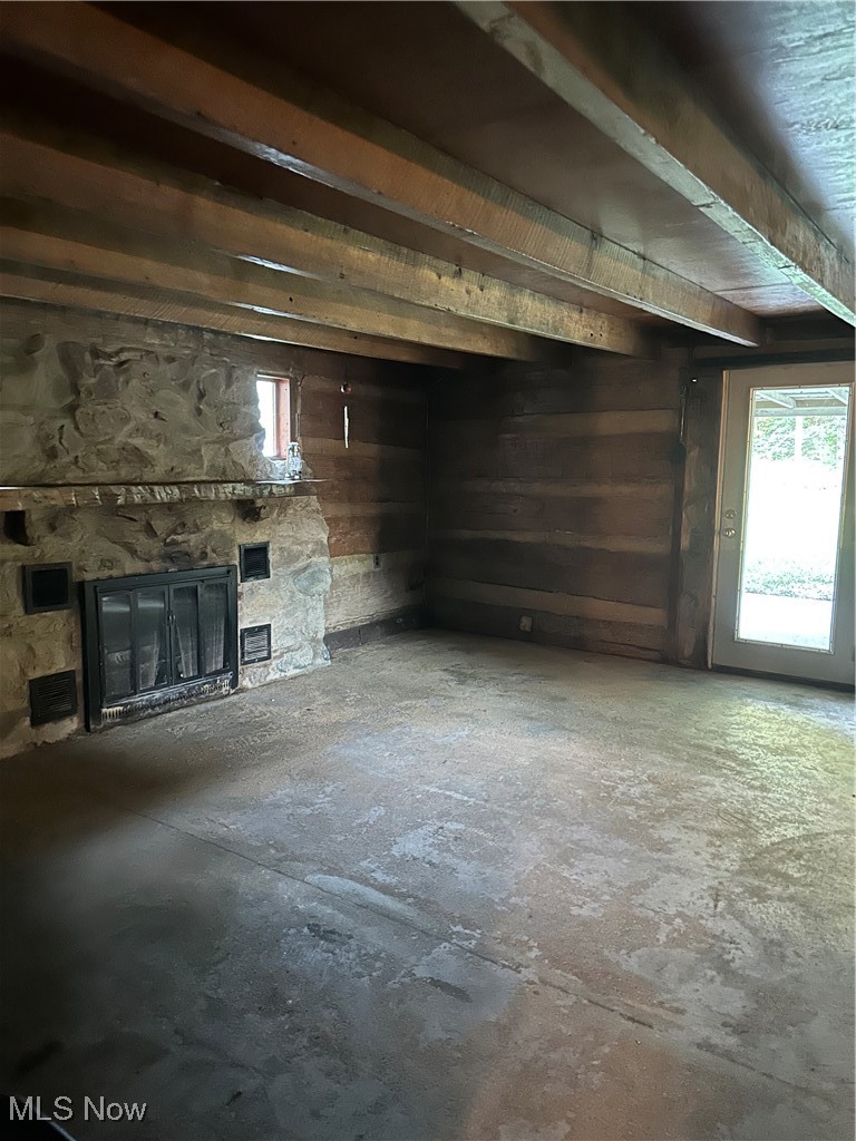 37114 Barber Ridge Road Woodsfield, OH 43793 - Photo 45 of 50 Unfurnished living room with a stone fireplace, wood walls, and concrete flooring