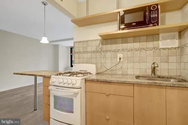 a kitchen with granite countertop cabinets stainless steel appliances and a counter space