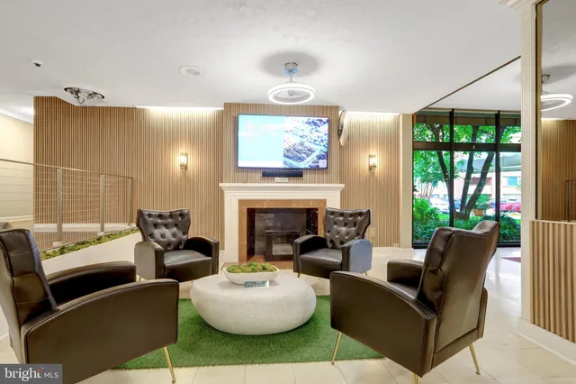 a living room with furniture a fireplace and a large window