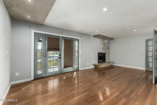 an empty room with wooden floor and fireplace