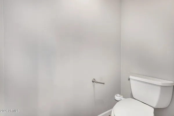 a white toilet sitting next to a white wall