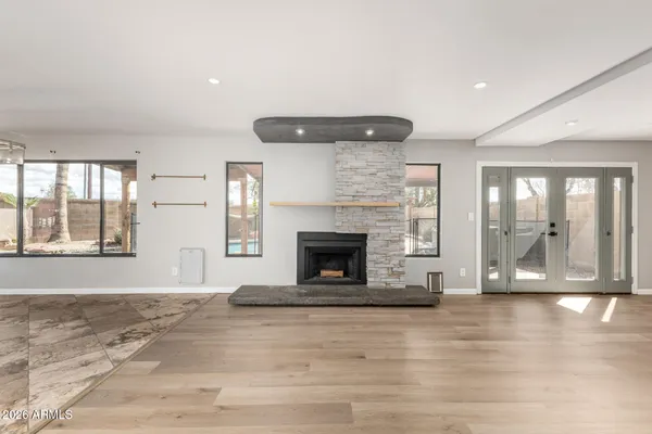 a view of an empty room with exposed radiator and fireplace