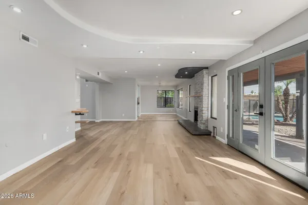 a view of a big room with wooden floor and windows