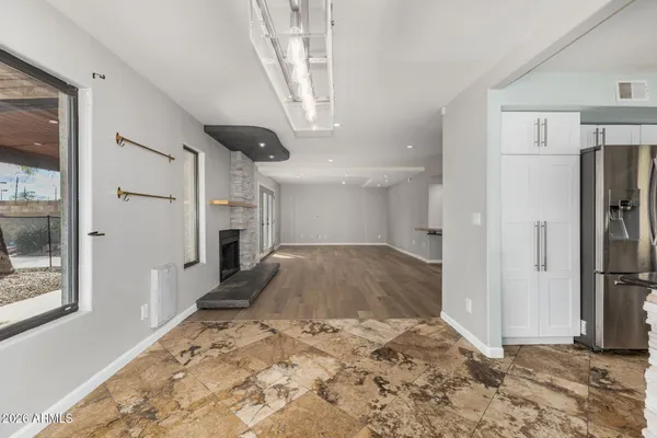 a view of a hallway with wooden cabinet and a refrigerator