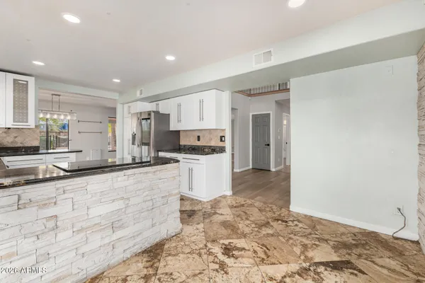 a large kitchen with a stove a sink a refrigerator and a granite counter tops