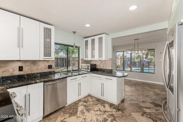a kitchen with stainless steel appliances granite countertop a sink and cabinets
