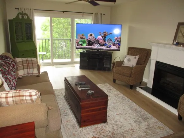 a living room with furniture a flat screen tv and a fireplace