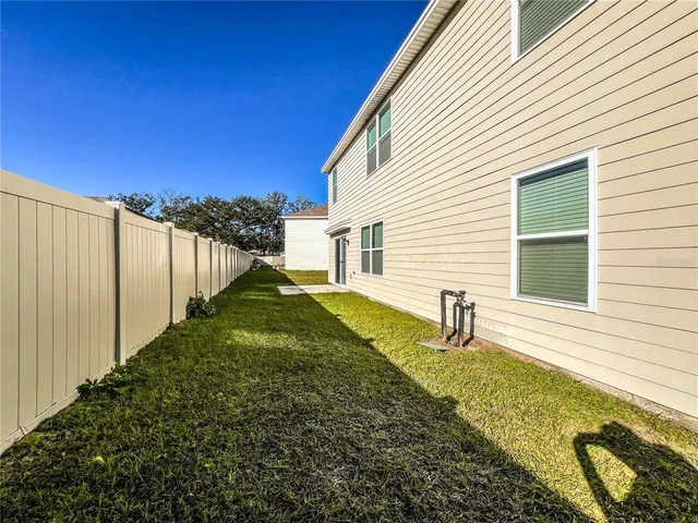 a view of a house with backyard and sitting area