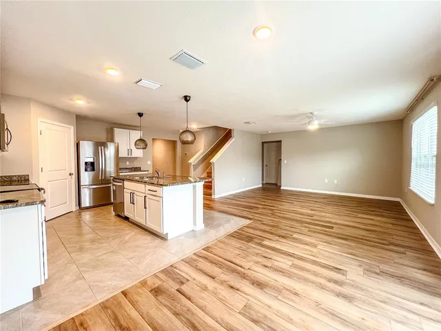 a view of a kitchen with wooden floor and electronic appliances