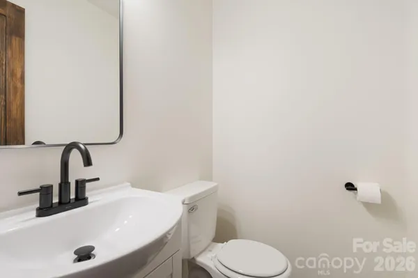 a bathroom with a sink a toilet and mirror