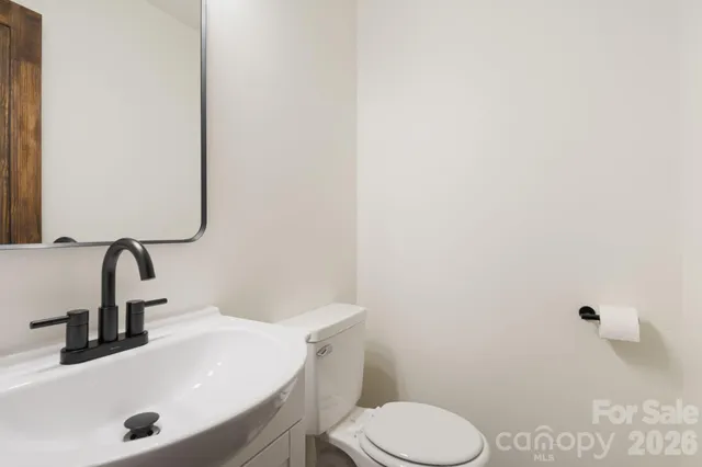 a bathroom with a sink a toilet and mirror