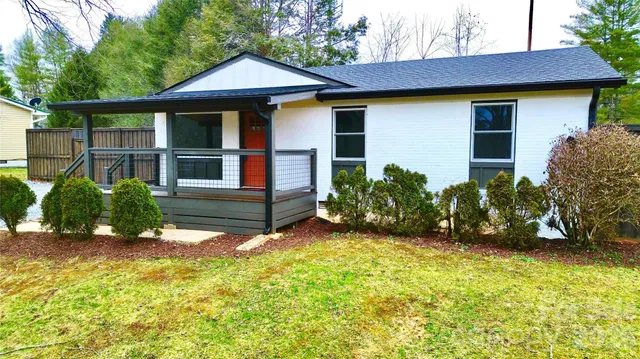 a view of a house with potted plants and a small yard