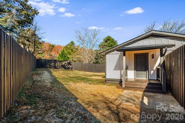 a view of a house with backyard and trees