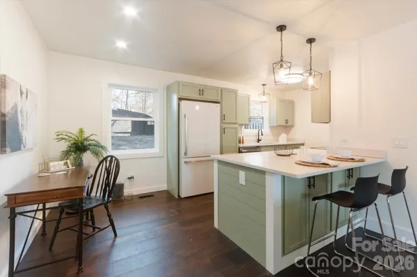 a kitchen with a table chairs refrigerator and cabinets