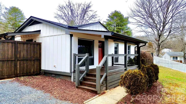a view of a house with wooden walls and floor to ceiling window and wooden fence