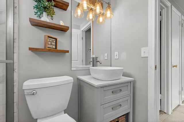 a bathroom with a toilet sink and mirror