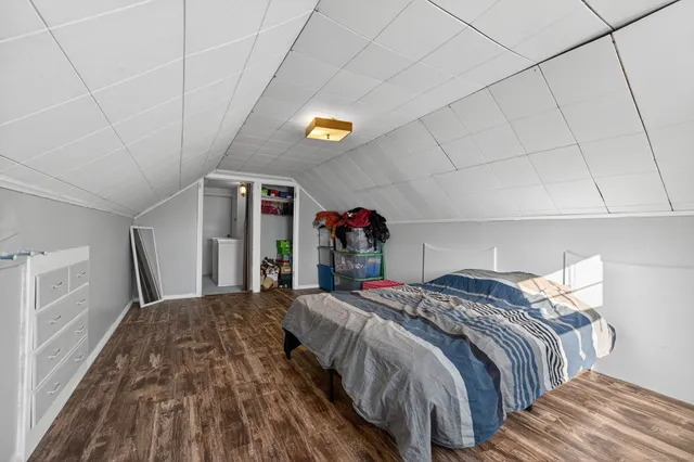 a bed sitting in a bedroom next to a larger window