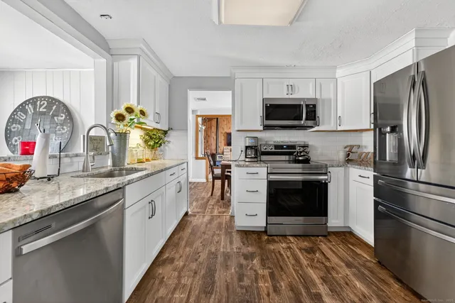 a kitchen with granite countertop a refrigerator stove and microwave