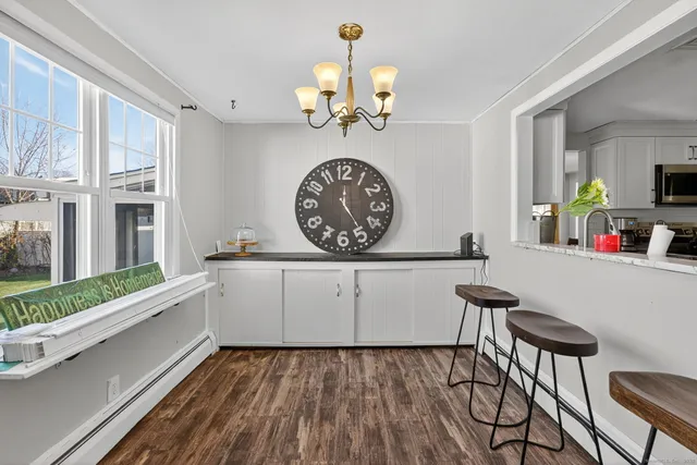 a view of a dining room with furniture a chandelier and wooden floor