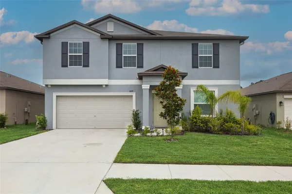 a front view of a house with a yard and garage