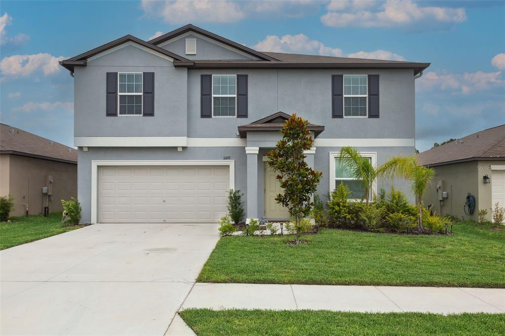 a front view of a house with a yard and garage