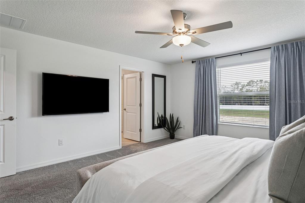 11693 Lavender Loop Spring Hill Spring Hill, FL 34609 - Photo 19 of 34 a bedroom with a bed and a flat screen tv