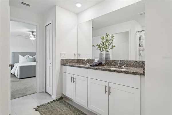 a bathroom with a granite countertop sink and a mirror